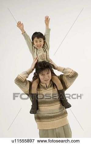 Stock Photo - Father carrying son on shoulders. Fotosearch