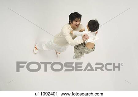 Stock Image - Father picking up son. Fotosearch