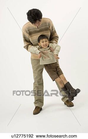 Stock Image - Father picking up son. Fotosearch