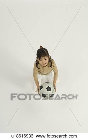 Stock Image - Girl holding soccer ball. Fotosearch