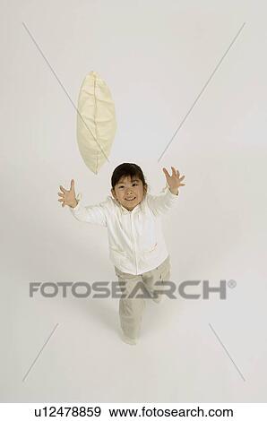 Stock Photo - Girl throwing cushion. Fotosearch