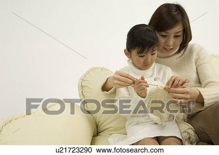 Stock Image - Mother teaching daughter to knit. Fotosearch