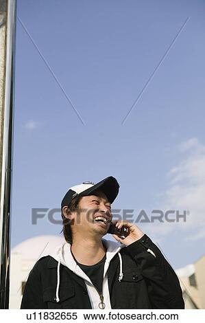 Stock Photography - Young man using mobile phone. Fotosearch