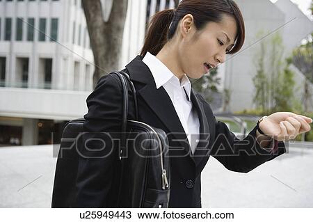 Young woman checking watch View Large Photo Image Stock Image - Young woman checking watch. Fotosearch
