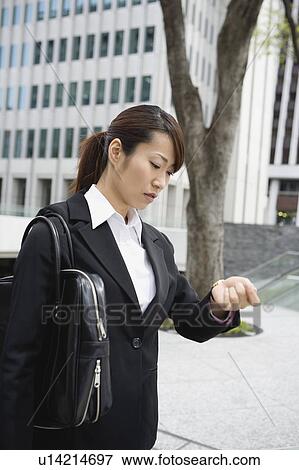 Young woman checking watch View Large Photo Image Stock Photo - Young woman checking watch. Fotosearch