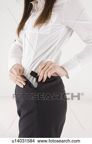 Picture - Young woman getting dressed. Fotosearch