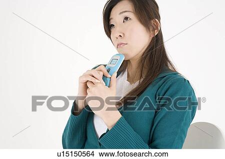 Picture - Young woman holding mobile phone. Fotosearch