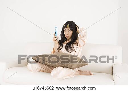 Young woman looking at mobile phone View Large Photo Image Stock Image - Young woman looking at mobile phone. Fotosearch
