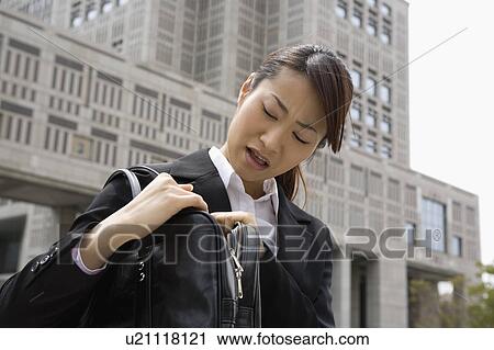 Young woman looking into bag View Large Photo Image Stock Image - Young woman looking into bag. Fotosearch
