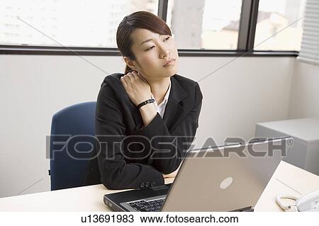 Young woman massaging shoulder View Large Photo Image Stock Image - Young woman massaging shoulder. Fotosearch