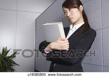 Young woman standing holding file View Large Photo Image Stock Photography - Young woman standing holding file. Fotosearch