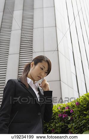 Stock Photo - Young woman using mobile phone. Fotosearch