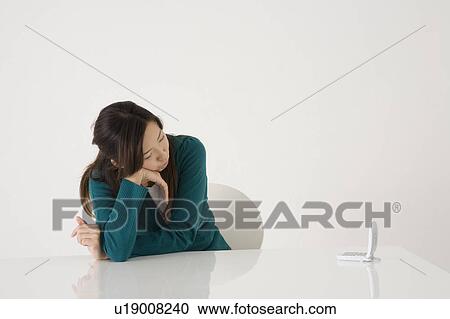 Stock Image - Young woman waiting for phone call. Fotosearch