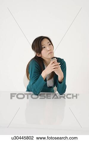 Stock Image - Young woman waiting for phone call. Fotosearch