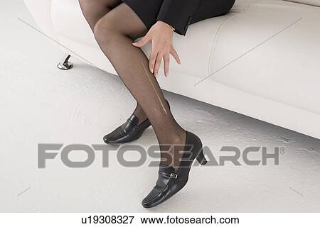 Stock Photo - Young woman with laddered stockings. Fotosearch
