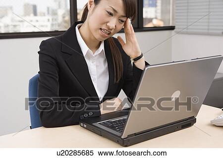 Stock Photography - Young woman working on computer. Fotosearch