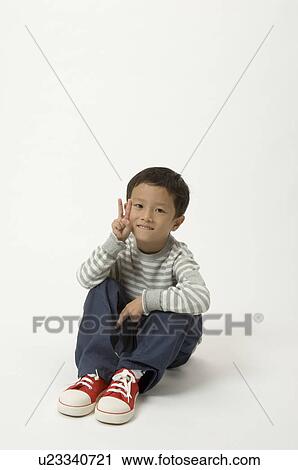 Stock Image - Elementary age boy giving peace sign. Fotosearch