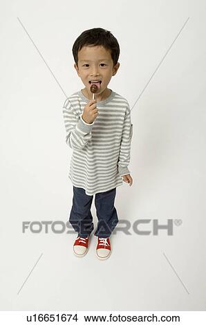 Elementary age boy licking lollypop View Large Photo Image Picture - Elementary age boy licking lollypop. Fotosearch