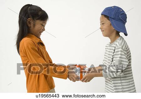 Elementary age child giving gift to friend View Large Photo Image Stock Image - Elementary age child giving gift to friend. Fotosearch