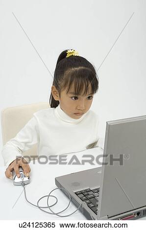 Stock Photography - Elementary age girl using laptop. Fotosearch