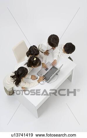 Stock Photo - Five elementary age children using laptop. Fotosearch