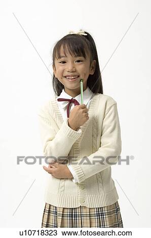 Stock Image - Portrait of elementary age girl standing. Fotosearch