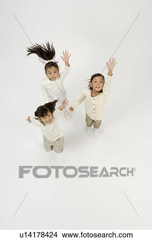 Picture - Three elementary age girls jumping. Fotosearch