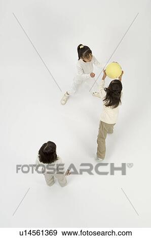 Three elementary age girls playing with ball View Large Photo Image Stock Photo - Three elementary age girls playing with ball. Fotosearch
