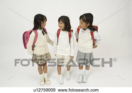 Stock Photo - Three elementary age girls standing. Fotosearch
