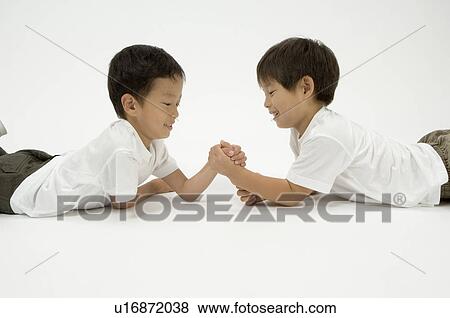 Stock Photo - Two elementary age boys arm wrestling. Fotosearch