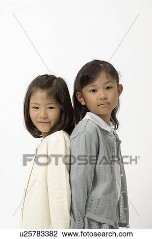 Stock Image - Two elementary age girls looking at camera. Fotosearch