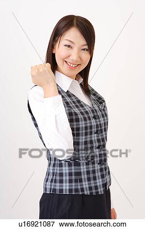 Stock Photo - A woman in formal attire expressing her victory with her fist up. Fotosearch