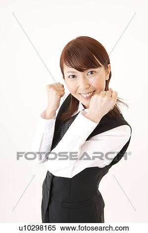 Stock Photography - A woman in formal attire expressing her victory with her fist up. Fotosearch