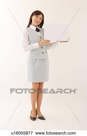 Stock Photo - A woman in formal attire holding a white blank message. Fotosearch