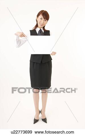 Stock Photo - A woman in formal attire holding a blank message. Fotosearch