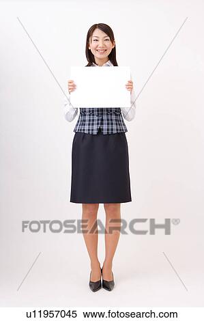 Stock Photography - A woman in formal attire holding a blank message. Fotosearch
