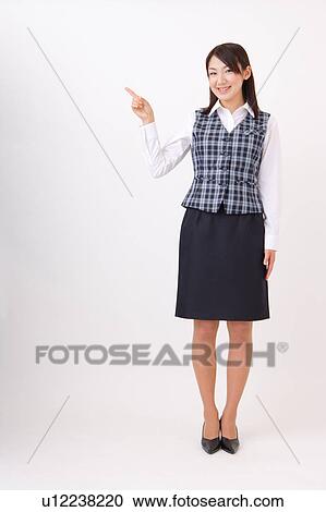 Stock Image - A woman in formal attire pointing a direction. Fotosearch