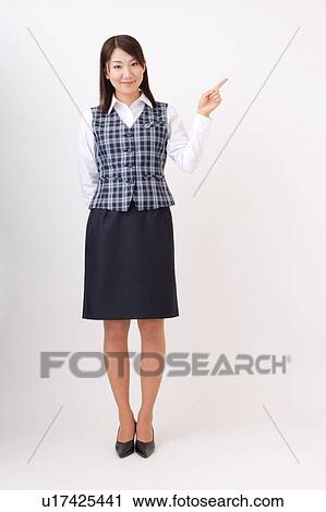 Stock Image - A woman in formal attire pointing a direction. Fotosearch