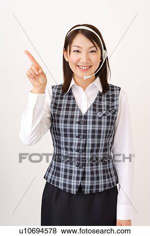 Stock Photo - A woman with headset pointing a direction. Fotosearch