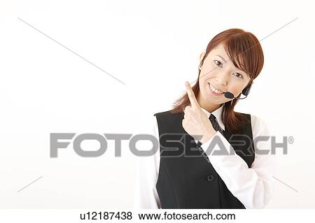 Stock Photo - A woman with headset pointing a direction. Fotosearch