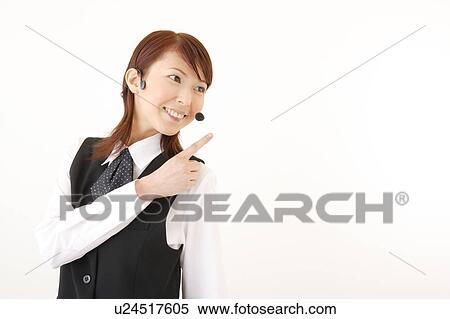 Stock Photography - A woman with headset pointing a direction. Fotosearch