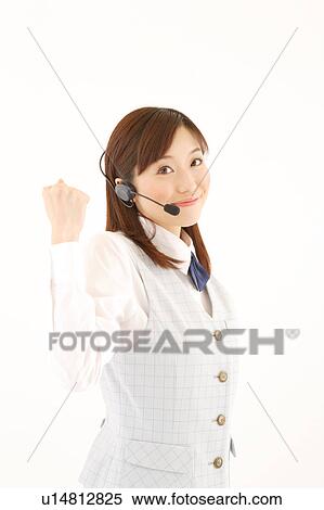 Stock Photography - A woman with headset punching in air. Fotosearch