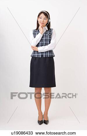 Stock Image - A woman with headset wondering. Fotosearch
