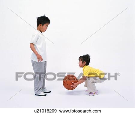 A boy and a girl playing with a basketball View Large Photo Image Stock Photo - A boy and a girl playing with a basketball. Fotosearch
