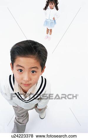 Stock Photo - A boy looking at camera while a girl stands behind. Fotosearch