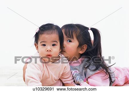 Stock Image - A girl holding a baby. Fotosearch