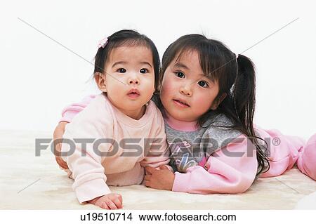 Picture - A girl holding a cute baby. Fotosearch