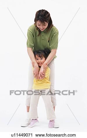 Stock Image - A girl holding her mother's hands. Fotosearch