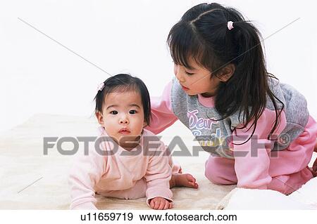 A girl looking after a baby View Large Photo Image Stock Photo - A girl looking after a baby. Fotosearch