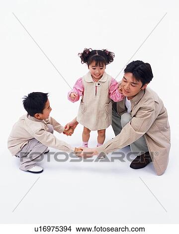Picture - A girl playing with her father and brother. Fotosearch